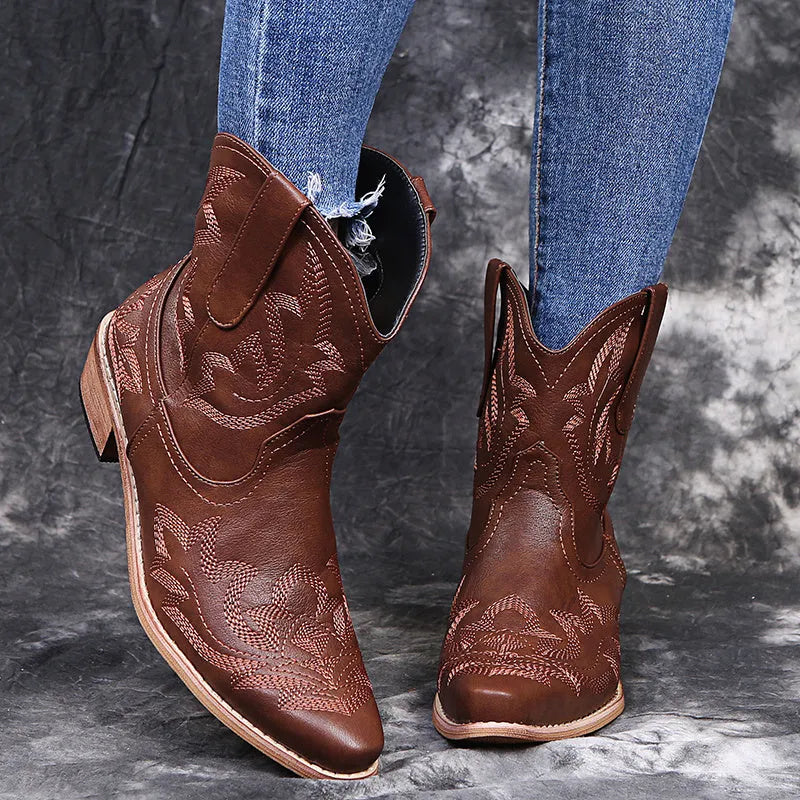 Women's blue embroidered cowboy boots with wedge heel and pointed toe on a white background.