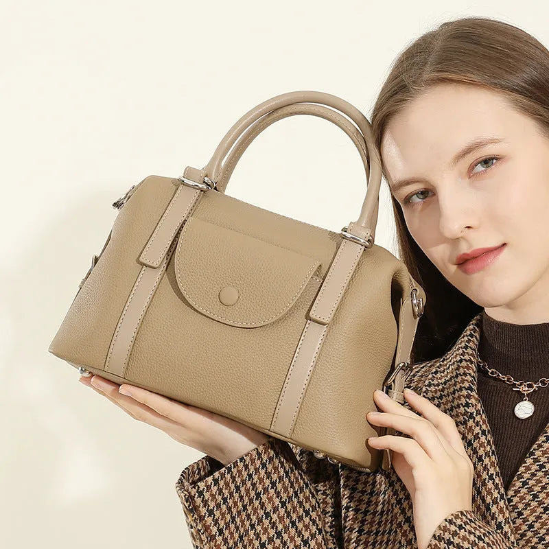 Genuine leather ladies handbag with lock detail in black, brown, or elephant grey.