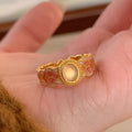Openable geometric women's ring with pink crystal enamel on a gold plated copper band.