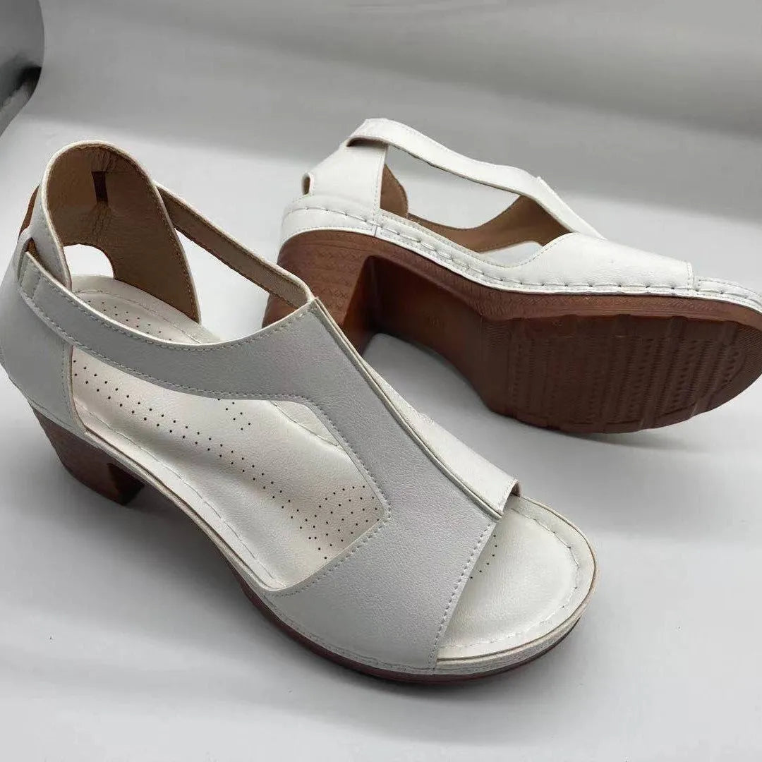 Women's white peep toe wedge sandals with a Roman style fish mouth toe and ankle buckle on a low rubber sole.