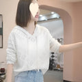 Woman wearing a blue crochet hollow knit hooded longsuit undershirt with long sleeves.