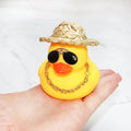 Cartoon yellow duck car ornament wearing a straw hat and sunglasses