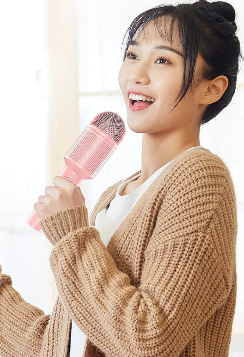 Bluetooth karaoke microphone with integrated speaker in pink, blue, or green colour.