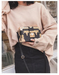Black or green women's hard-shell flap-over shoulder bag with single adjustable strap