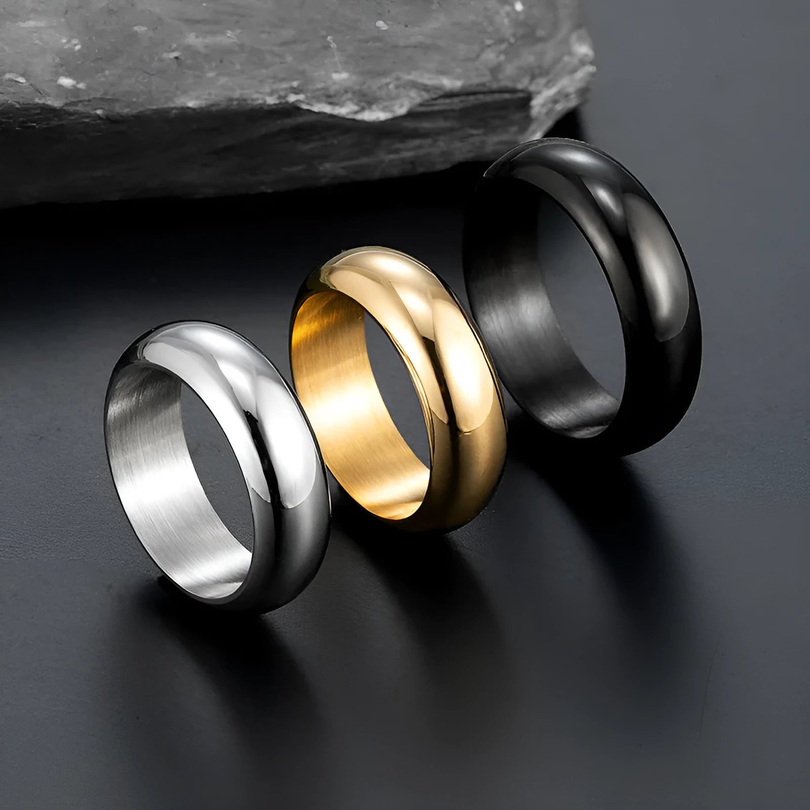 Glossy electroplated titanium steel ring shown in black, gold, and steel colour on a neutral background.