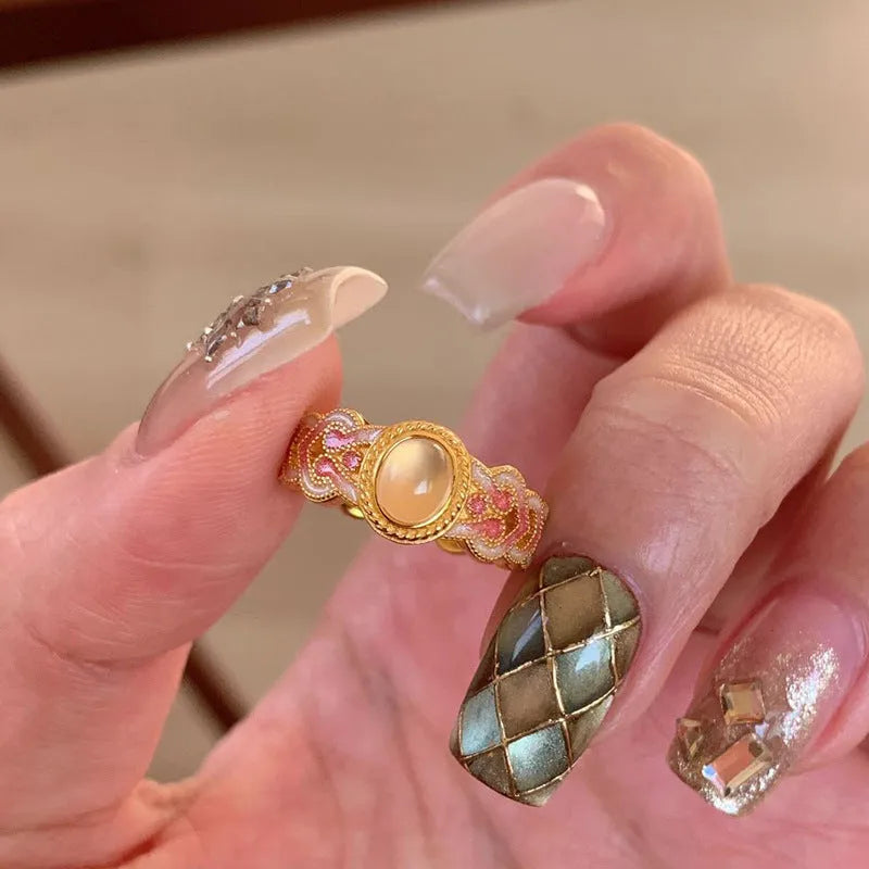 Openable geometric women's ring with pink crystal enamel on a gold plated copper band.