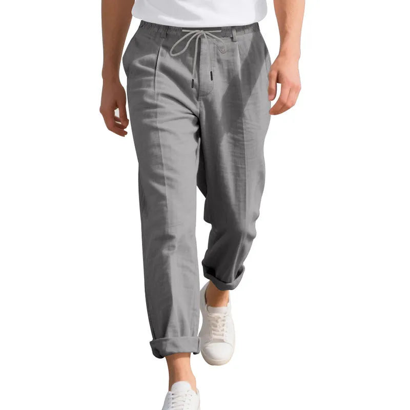 Man wearing light khaki linen casual trousers with a drawstring waist and straight leg.