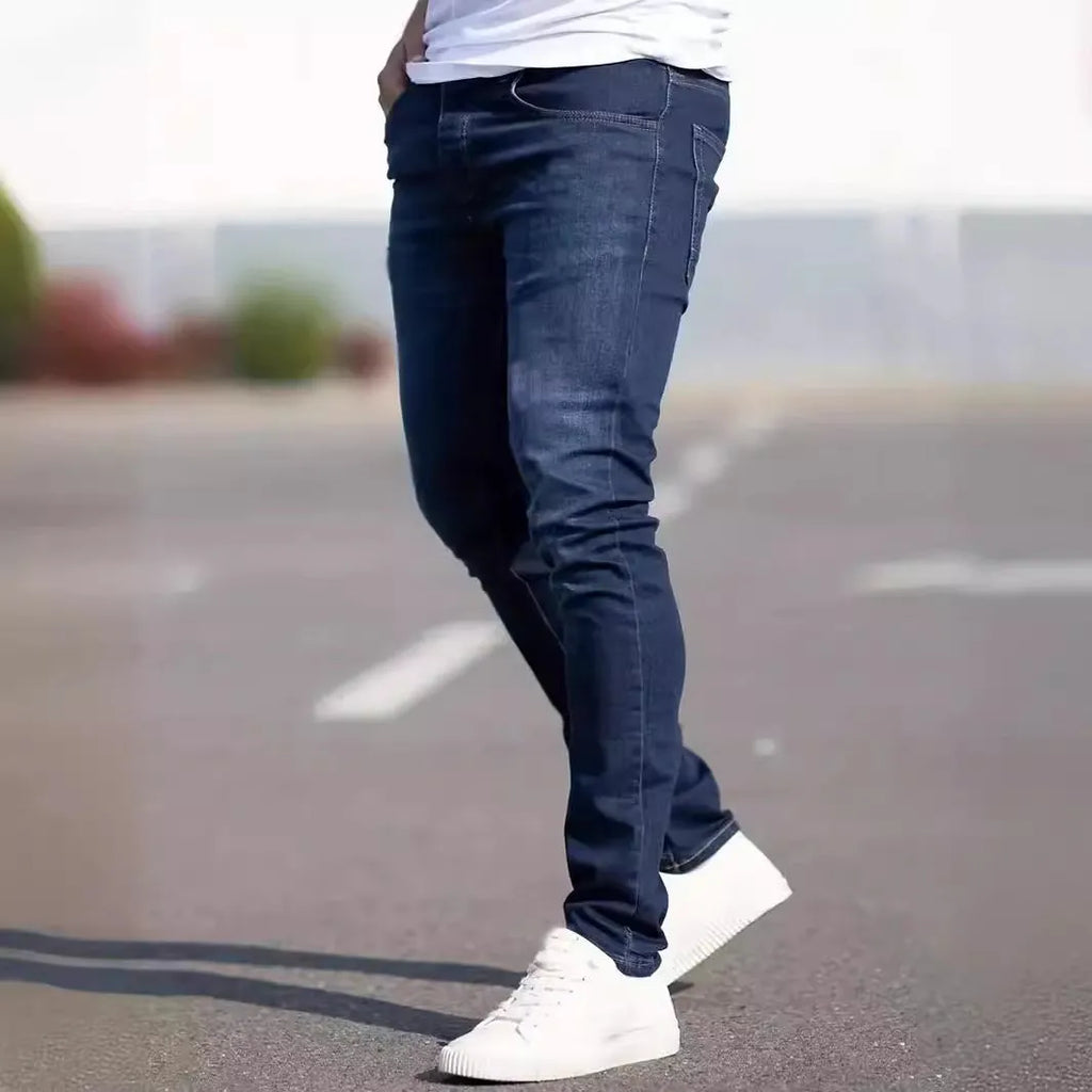 Man wearing dark blue slim-fit stretch cotton jeans with a skinny leg style.