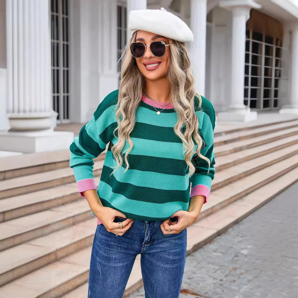 Women's loose fit acrylic sweater in blue with stripes, showing round neck and long sleeves.