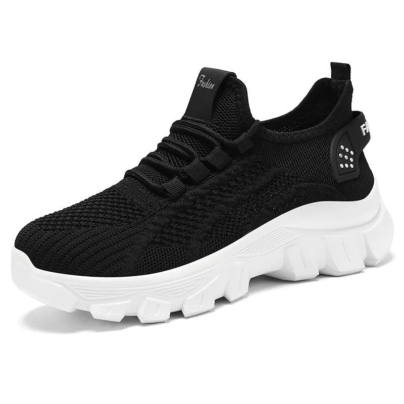 Women's white Flyknit sneakers with thick PVC sole and lace-up design on a neutral background.