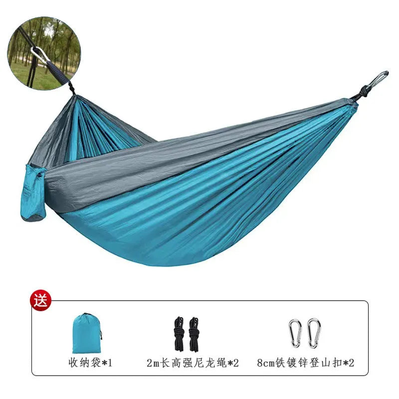 Blue parachute nylon outdoor camping hammock hung between two trees, showing its full 270 cm length.