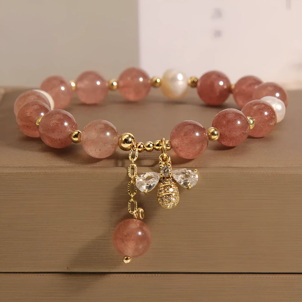 Women's bracelet with strawberry quartz beads, freshwater pearls, and a bee charm.