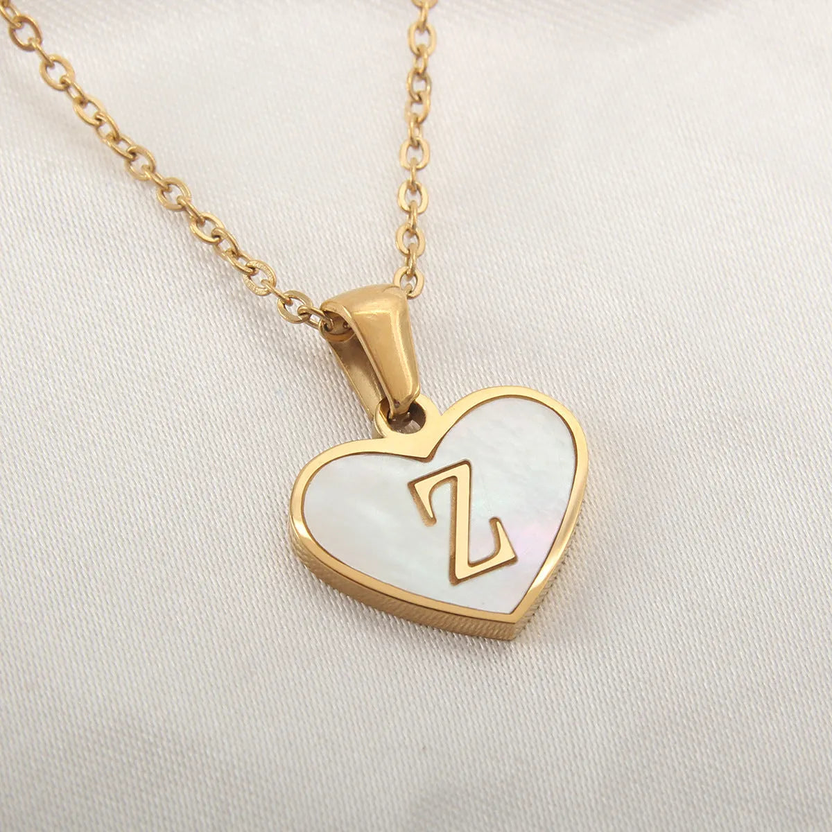 Gold heart necklace with white shell pendant and initial charm on 45cm adjustable chain