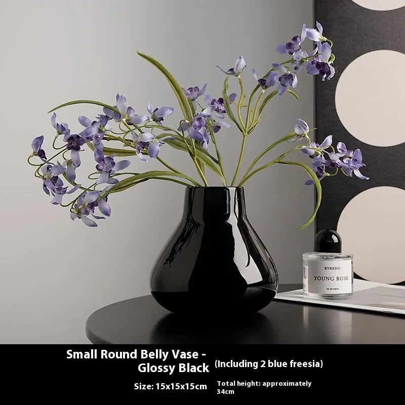 Ceramic round belly vase with coloured glaze finish in black or white, shown with artificial orchid stems