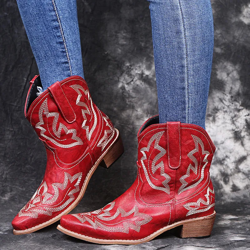 Women's blue embroidered cowboy boots with wedge heel and pointed toe on a white background.