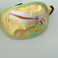 Powder blue messenger bag-style dog backpack for holding poop bags, shown with adjustable chest strap.