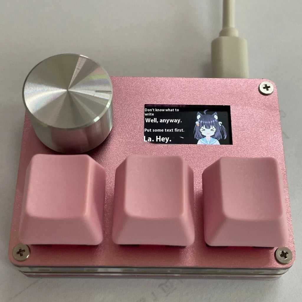 Customisable magnetic axis gaming keypad with programmable knob and colour IPS screen on desk.