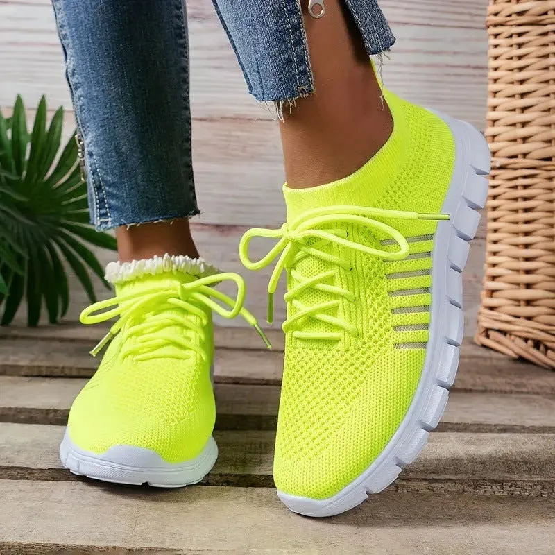 Breathable women's casual flat shoes in flying knit mesh with front lace tie.