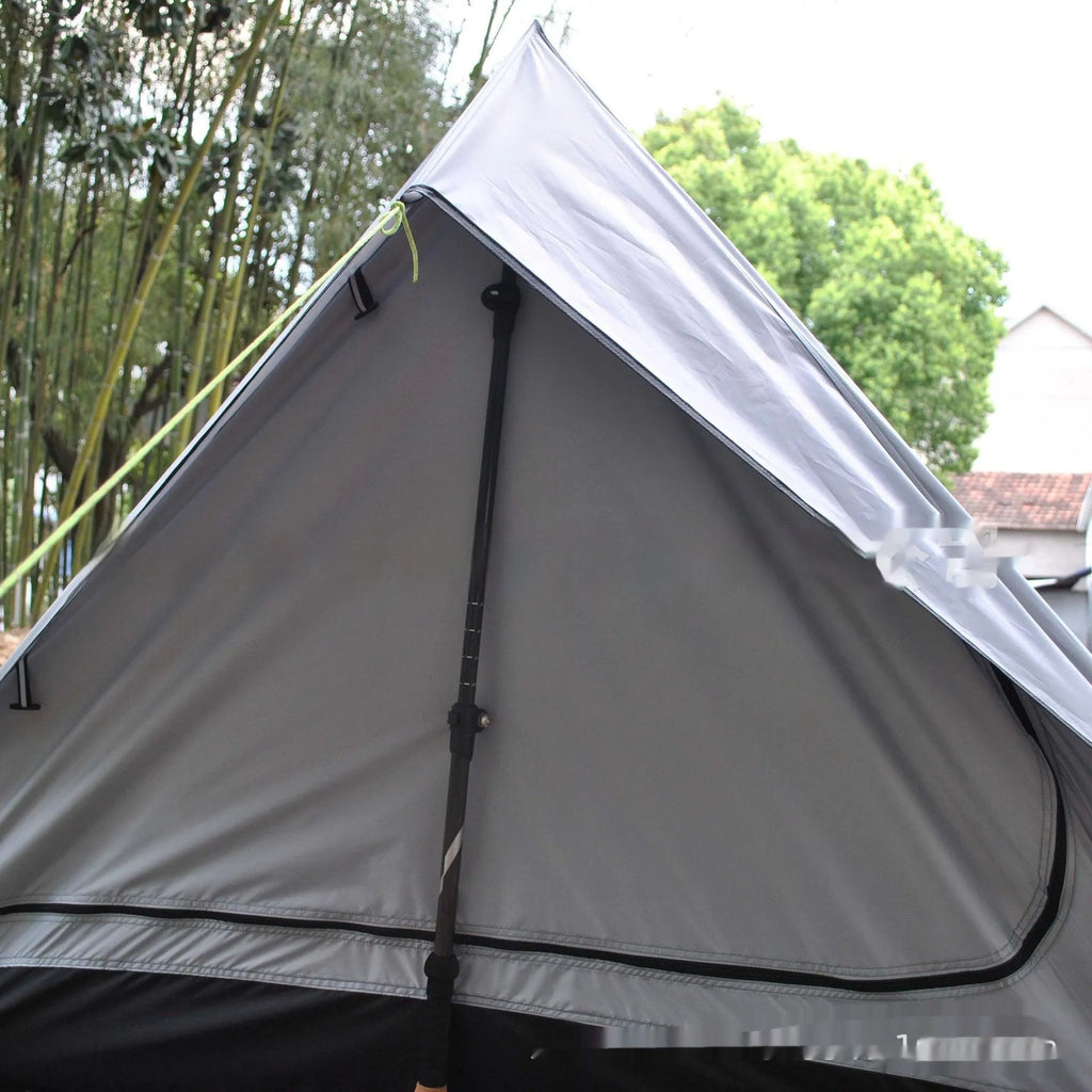 Brown or white A-frame pole-free cabin tent erected with hiking cane supports
