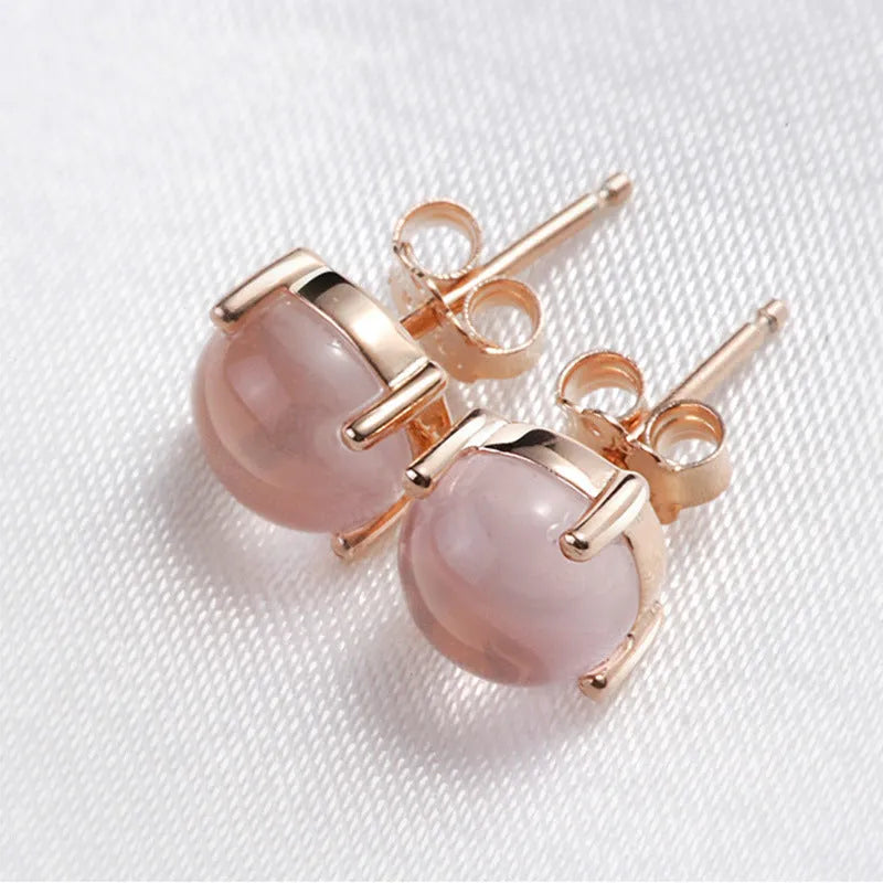 Rose gold drop-shaped stud earrings with crystal inlay detail.