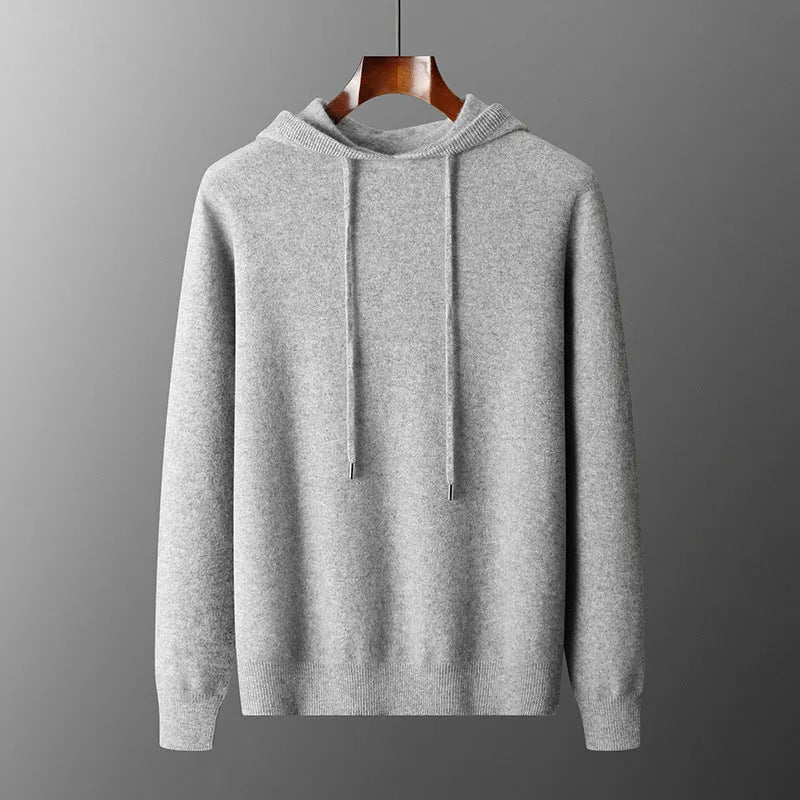 Man wearing a light grey hooded cashmere sweatshirt and matching long pants from a winter leisure set.