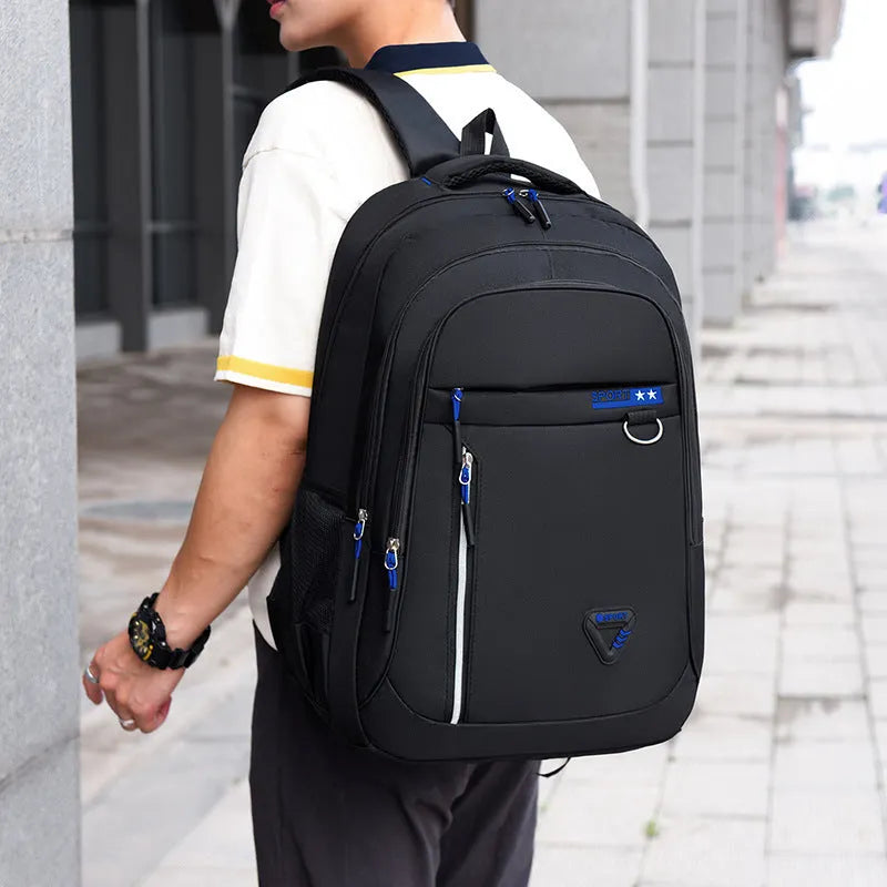 Men's Oxford cloth schoolbag in black with letter pattern, showing large capacity and air pillow shoulder straps.