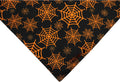 Reversible Halloween dog bandana with pumpkin and spider web designs in black and orange colours