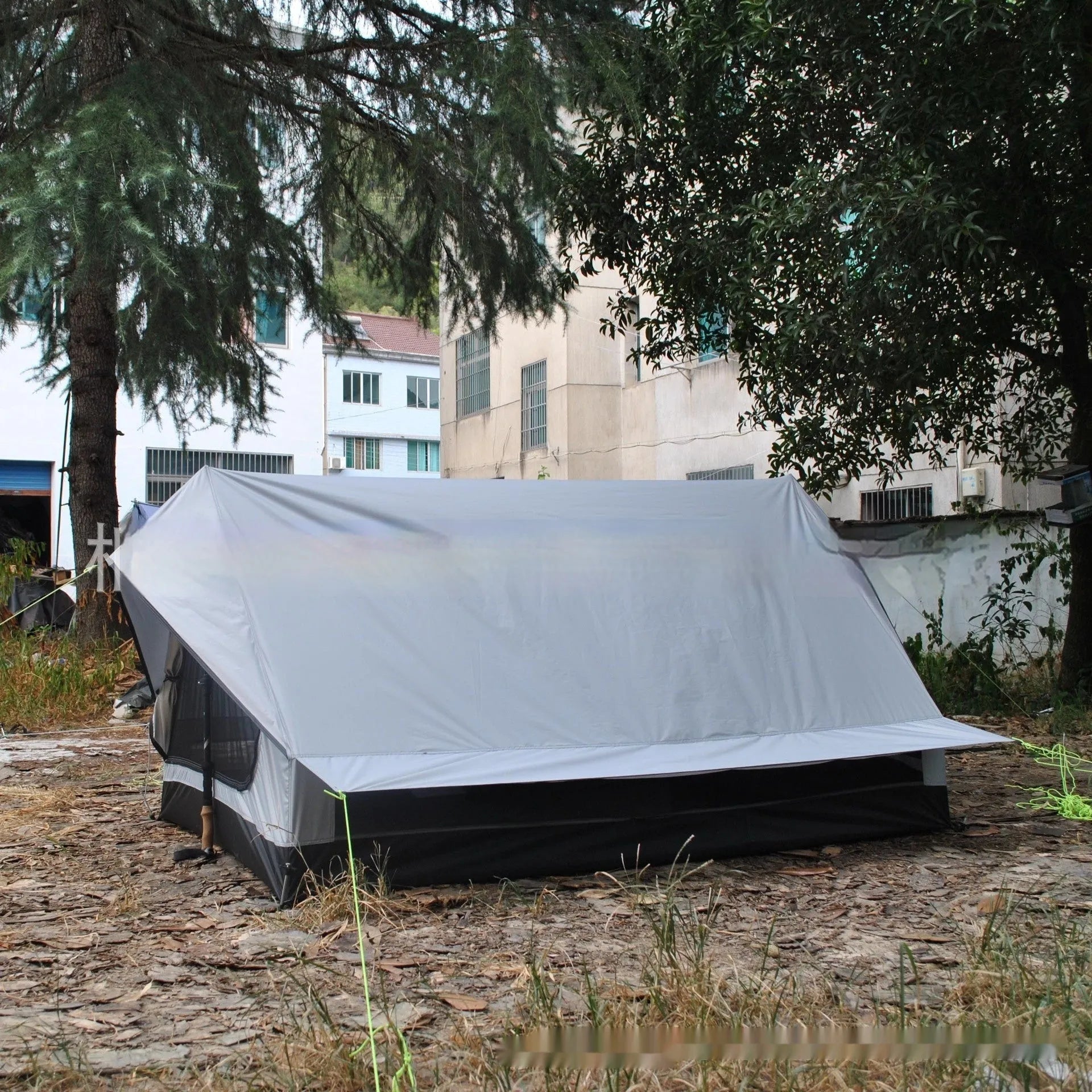 Brown or white A-frame pole-free cabin tent erected with hiking cane supports