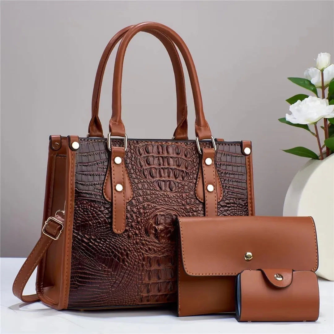 Women's burgundy three-piece PU leather bag set showing crossbody bucket bag, wallet, and card holder with minimalist texture.