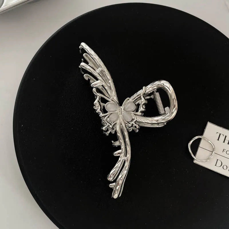 Electroplated silver metal hair barrettes in various designs including cross, wave, and bow shapes.