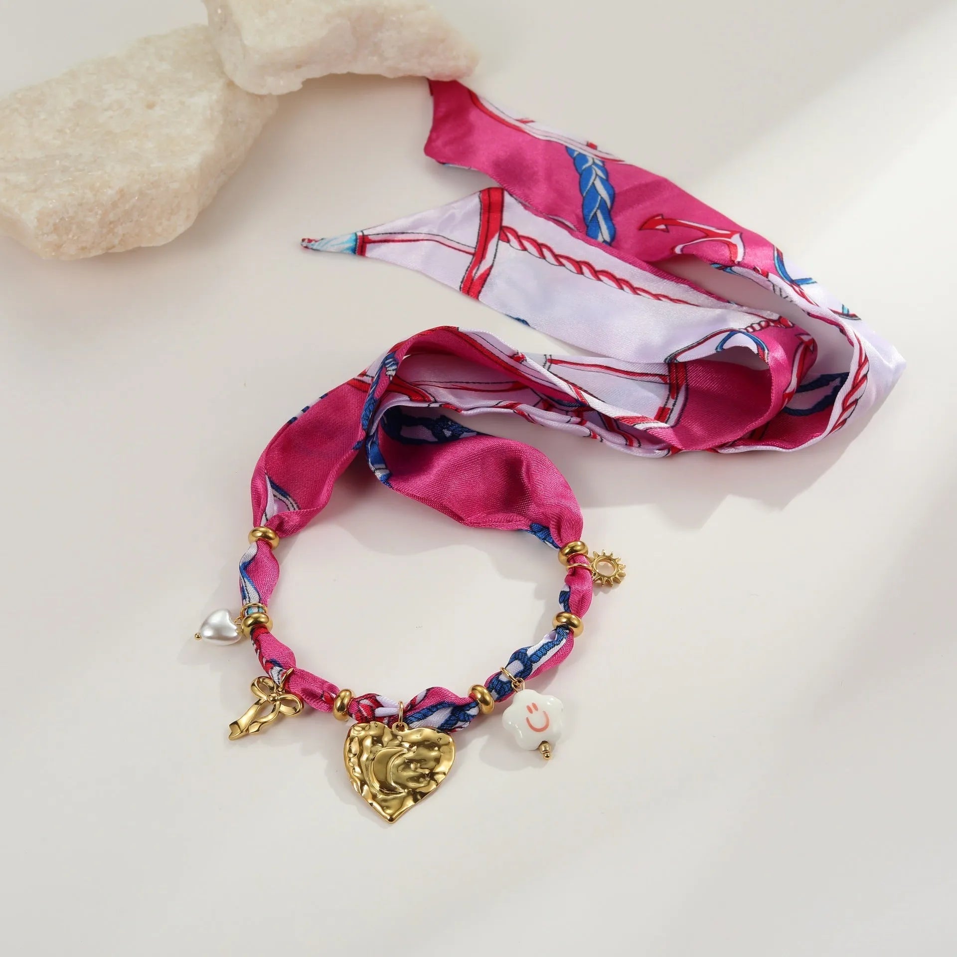 Gold geometric love pendant necklace and matching bracelet set on a white background
