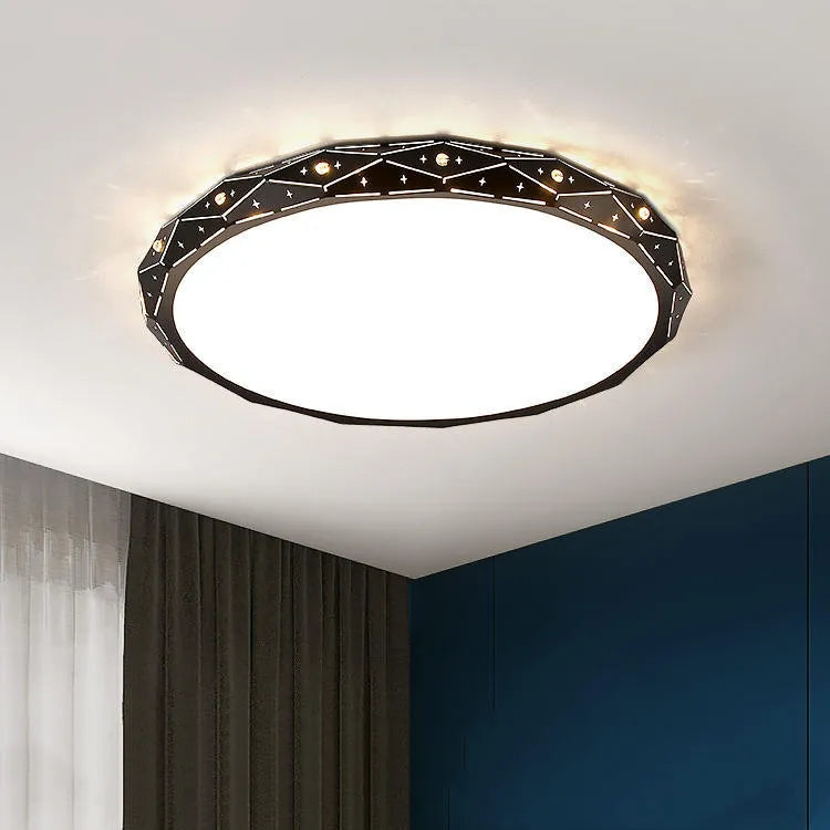 Round flush mount LED ceiling light with black iron frame on a white ceiling.