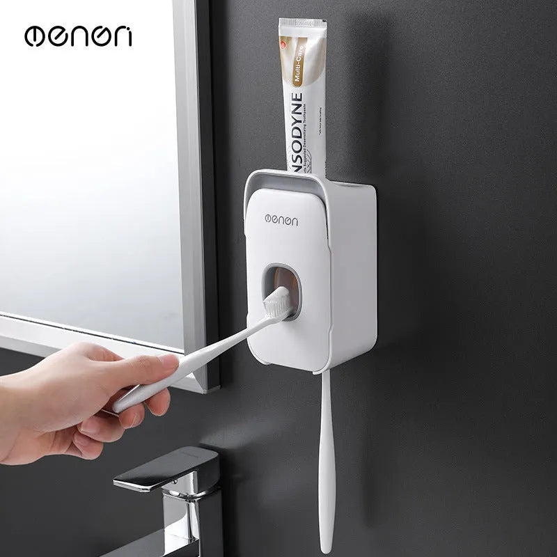 Blue automatic toothpaste dispenser mounted on a bathroom wall with a toothbrush below.