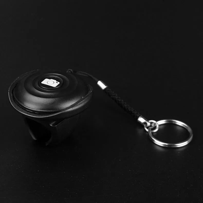 Black Bluetooth remote shutter control for smartphone photography with 10+ metre wireless range.