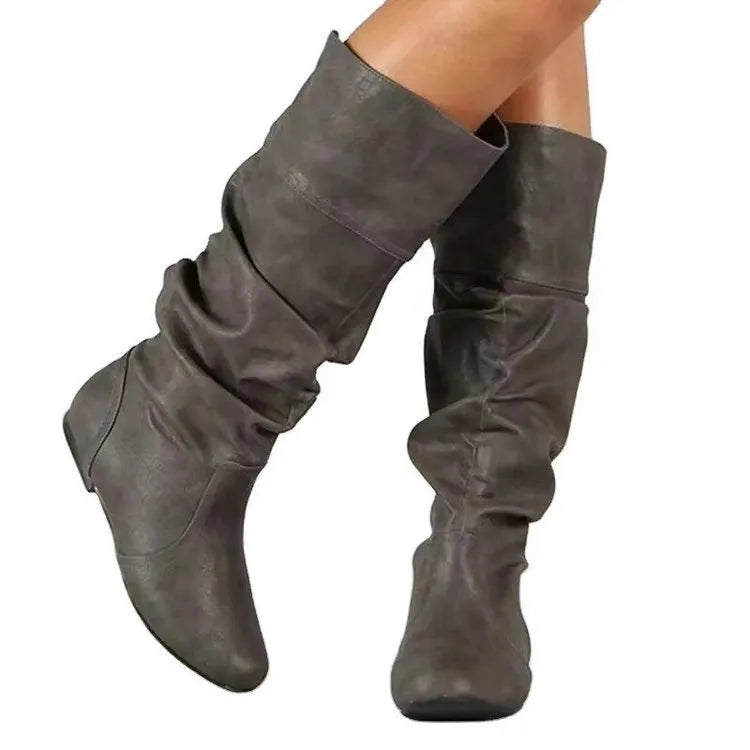 Women's flat black slip-on ankle boots with round toe and high shaft on a rubber sole.