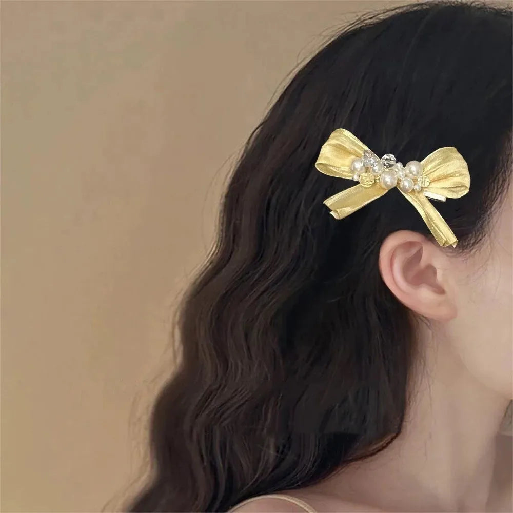 Yellow bow barrette with rhinestone and pearl on duckbill clip for women