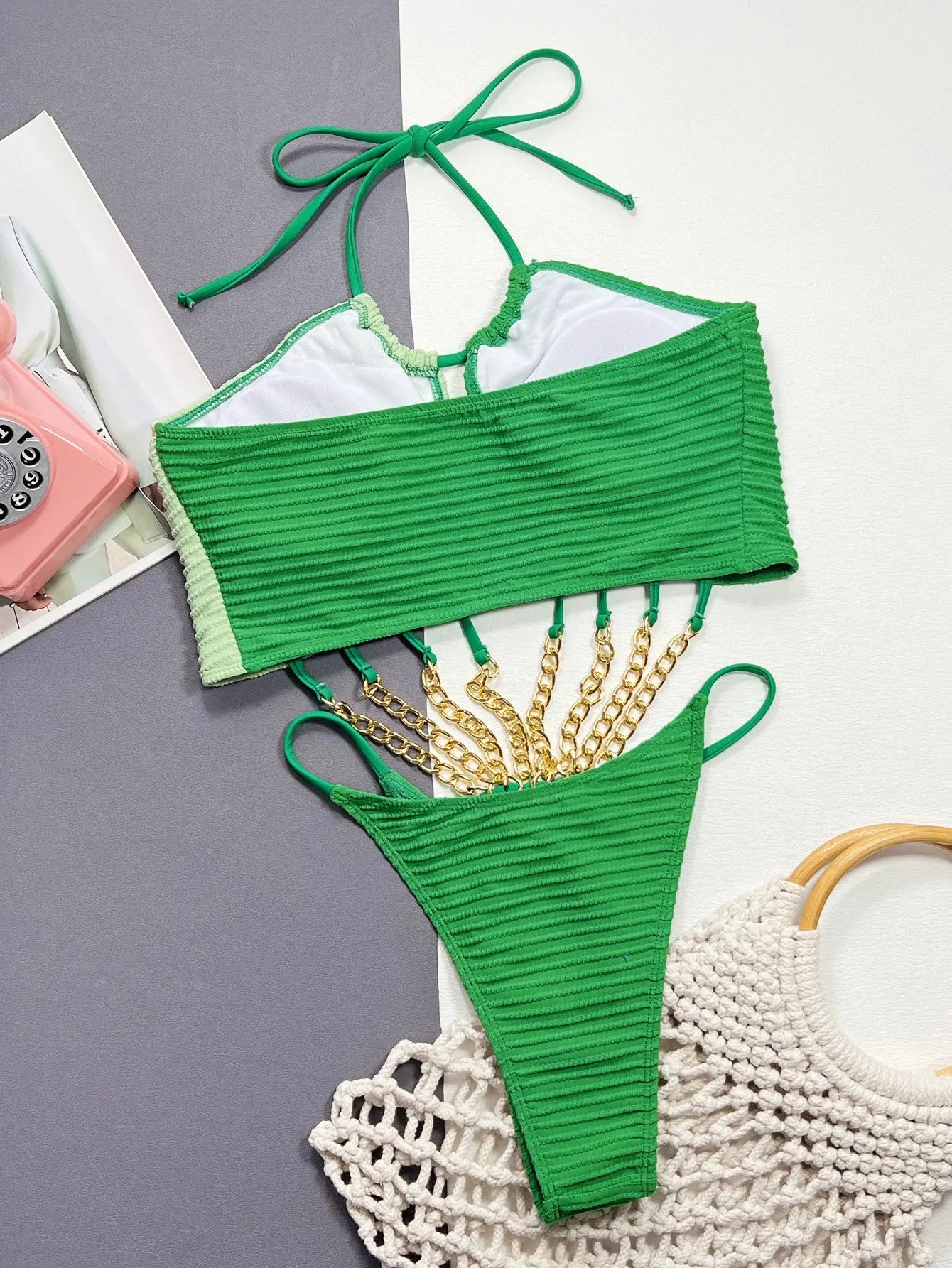 Green women's one-piece swimsuit with hollowed side panels on mannequin