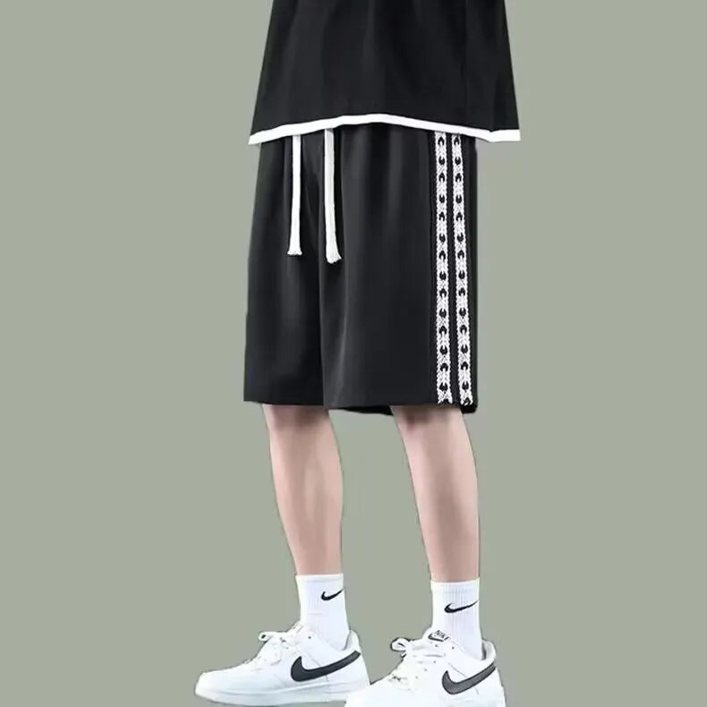 Men's loose-fit grey track pants with an elasticated waist on a neutral background.
