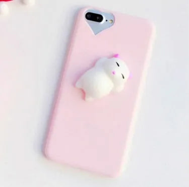 A soft pink silicone iPhone case featuring a raised 3D cartoon cat design on the back.