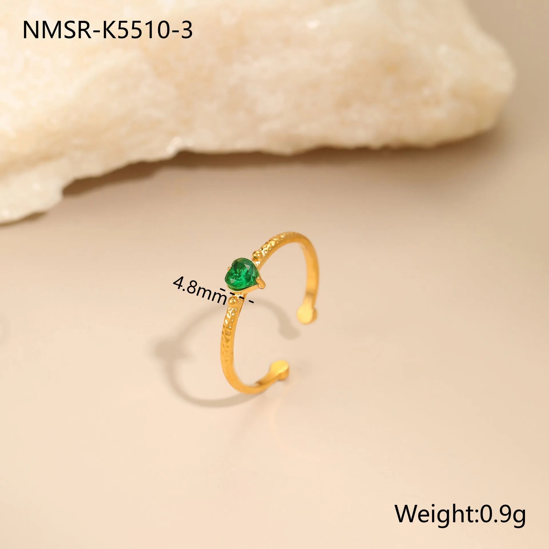 Open-ended stainless steel ring with a geometric heart shape inlaid with green zirconium on a plain background.