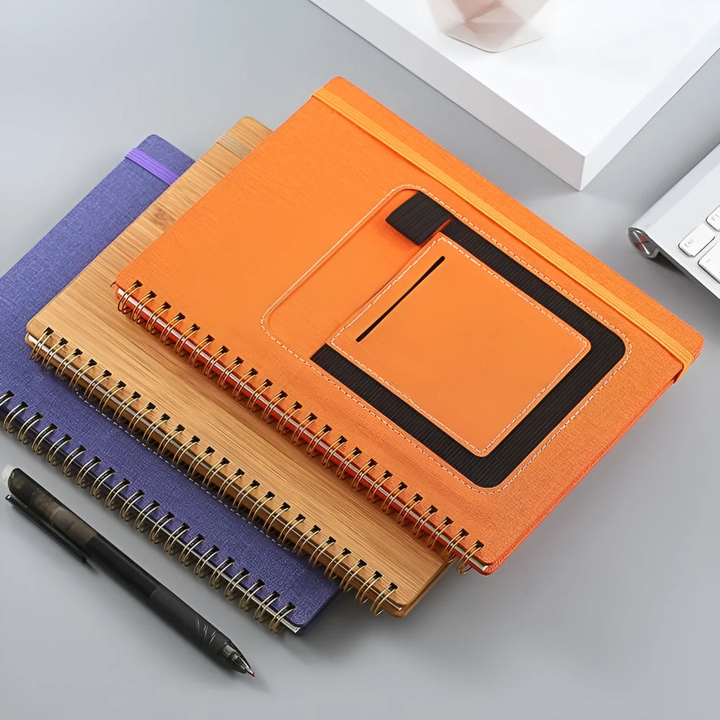 Erasable coil notebook with customisable cover options on waterproof rock stone paper, shown with pen.
