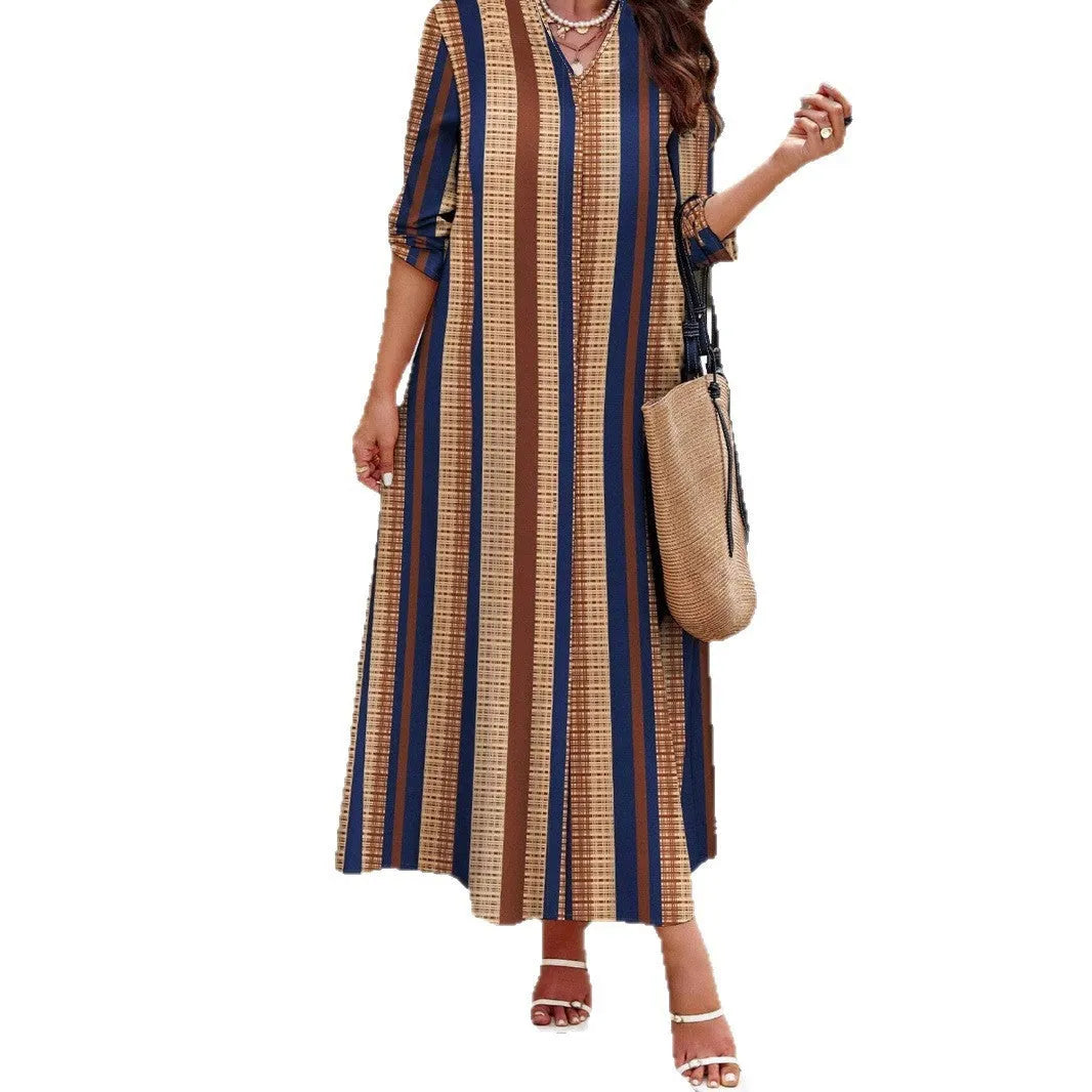 Camel coloured women's long dress with vertical stripes, V-neck, and long sleeves on a mannequin.
