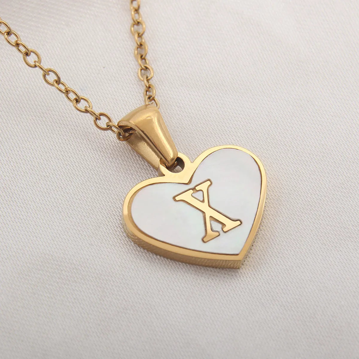 Gold heart necklace with white shell pendant and initial charm on 45cm adjustable chain