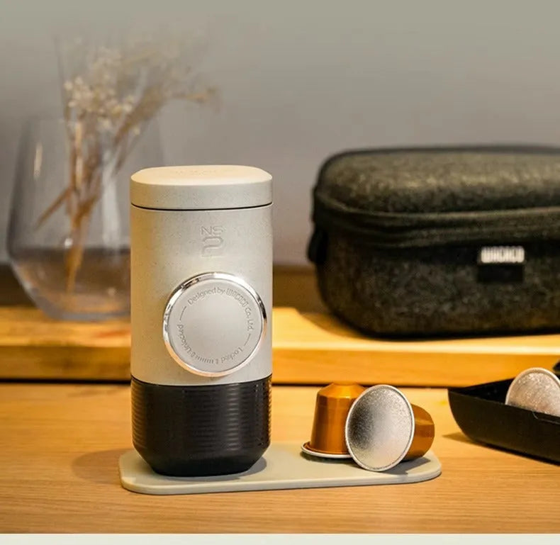 Olive gray manual espresso portable capsule coffee machine with storage bag and accessories on outdoor table