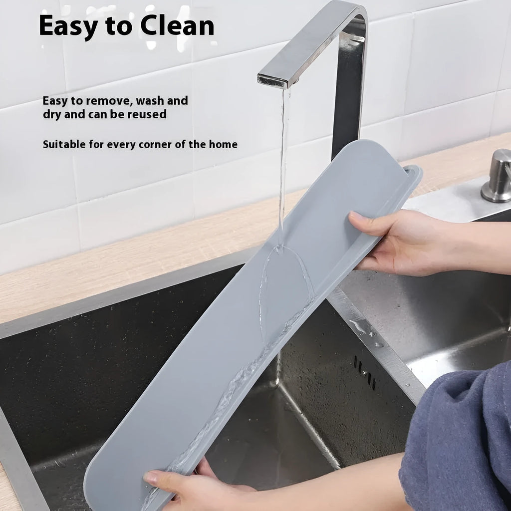 Thick grey silicone sink water blocking plate resting on a kitchen sink edge.