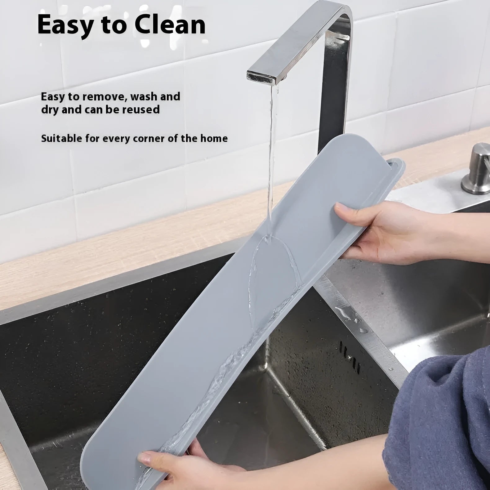 Thick grey silicone sink water blocking plate resting on a kitchen sink edge.