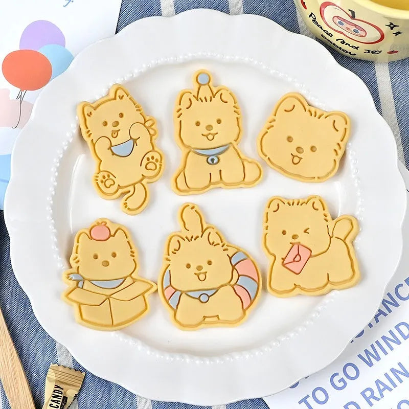 Three-dimensional plastic biscuit mold showing cartoon puppy designs including birthday hat and swimming ring motifs