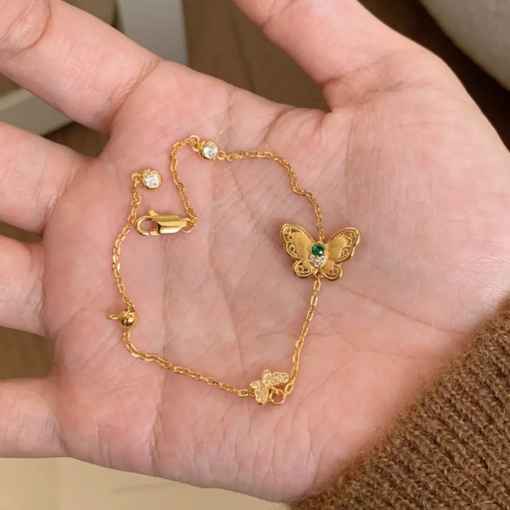Gold copper hollow butterfly bracelet with wire drawing finish on display