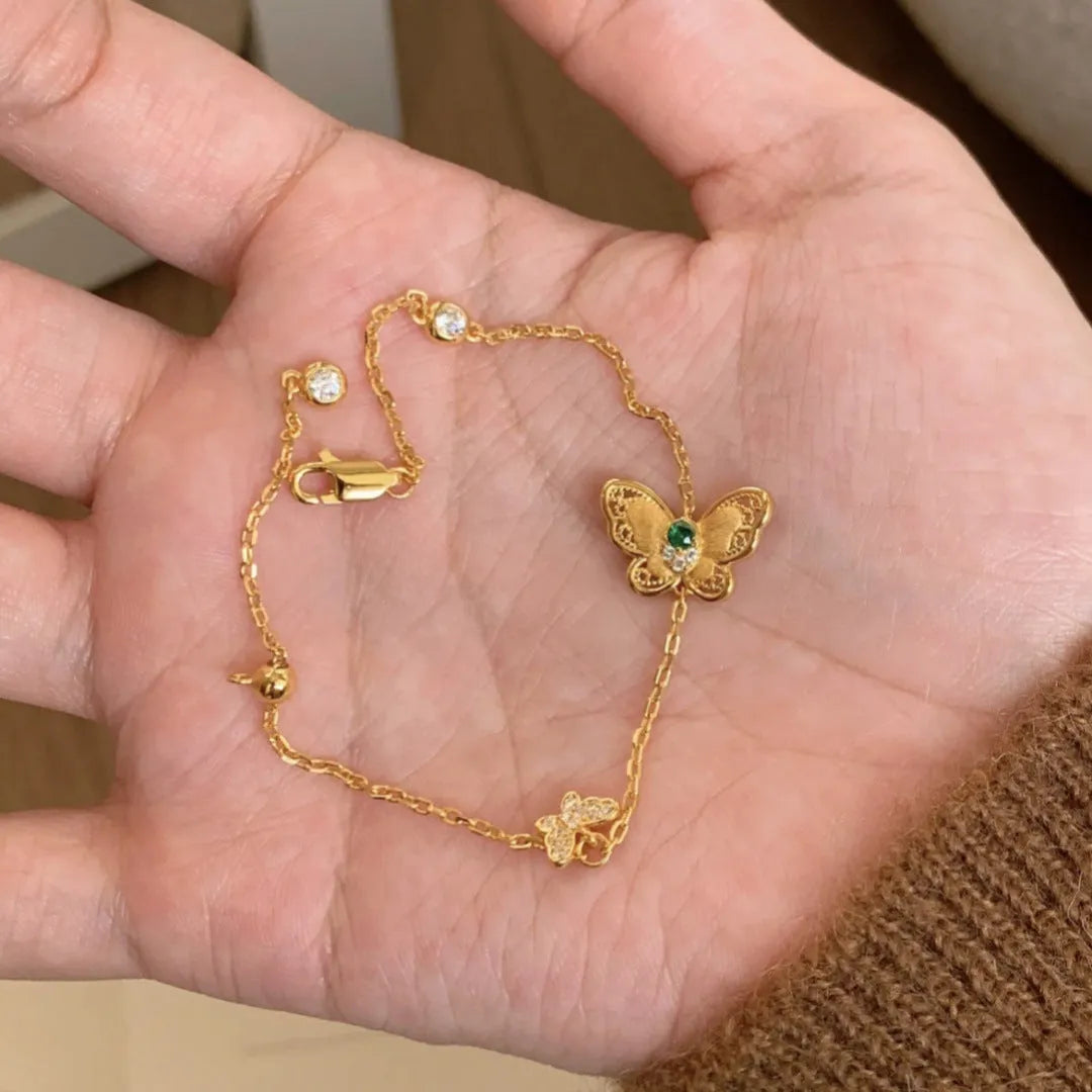 Gold copper hollow butterfly bracelet with wire drawing finish on display