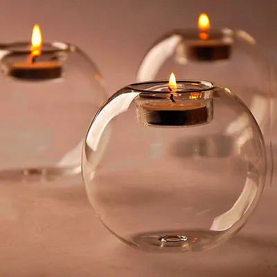 Handmade European hollow glass candle holder in round geometric design on table.